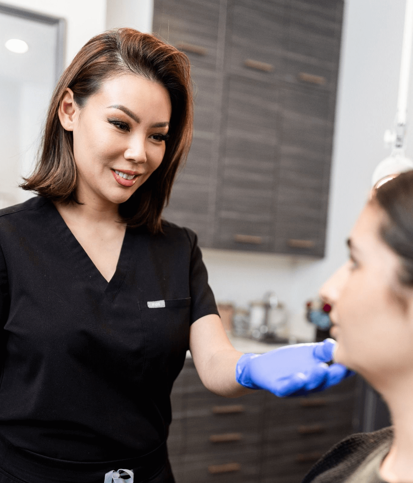 Nurse practitioner evaluates facial proportions and skin quality before facelift surgery.
