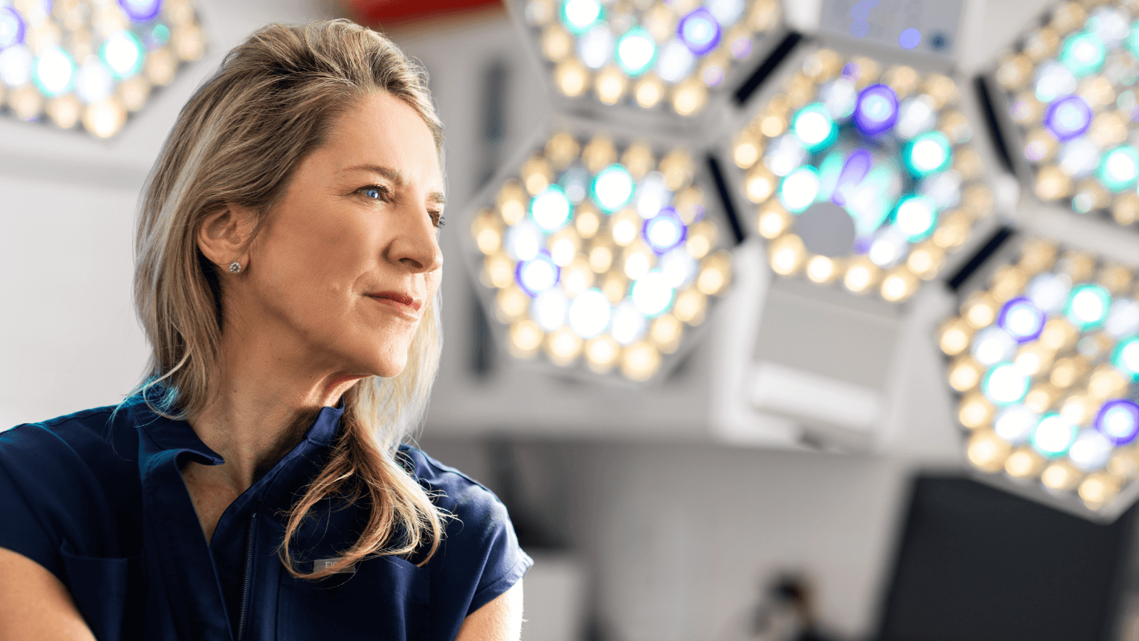 A surgeon in the surgical suite under bright lights, illustrating the expertise and care provided for tummy‑tuck procedures.