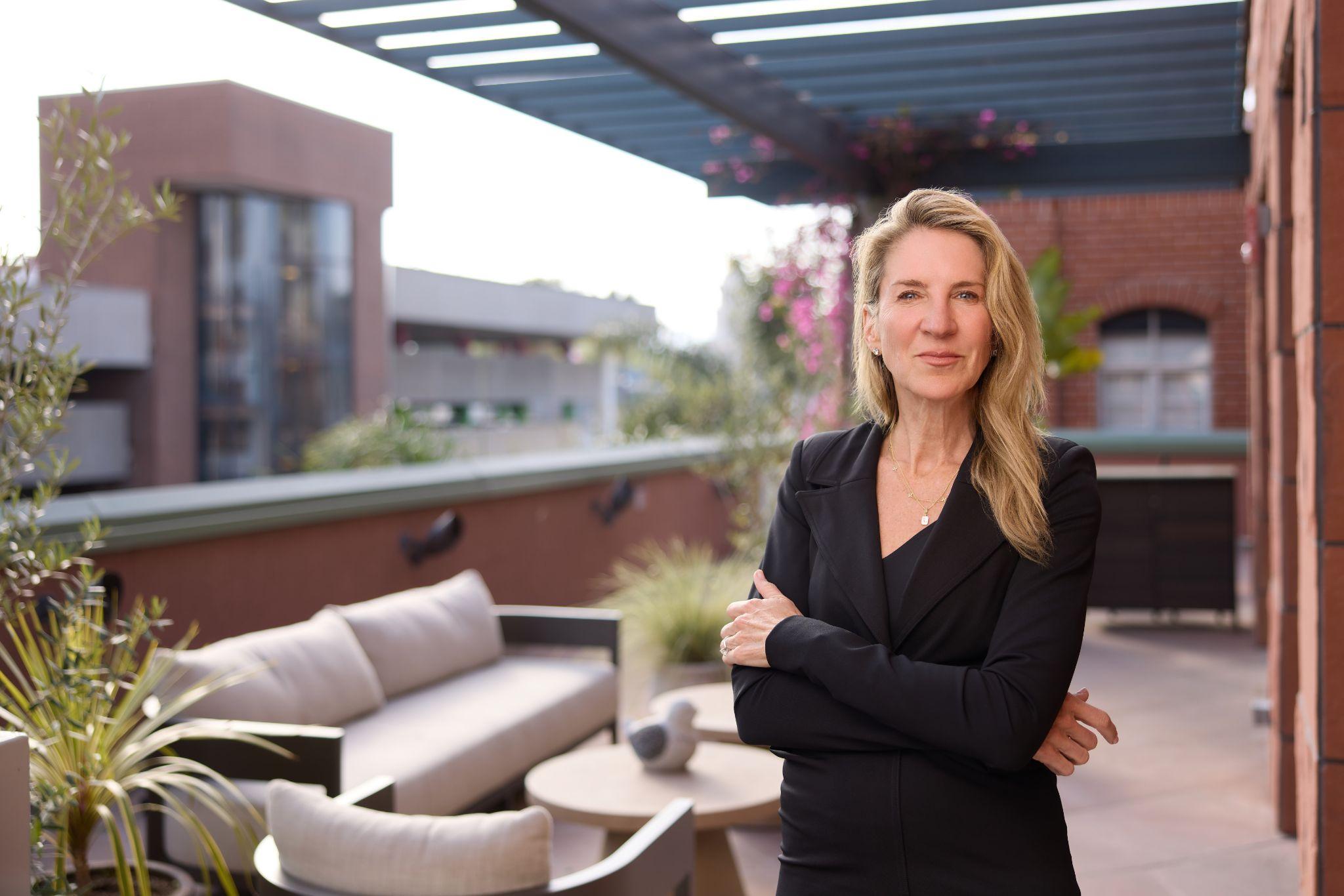 Dr. Lisa Cassileth, board-certified plastic surgeon, standing on the outdoor terrace at The Practice Healthcare in Beverly Hills.