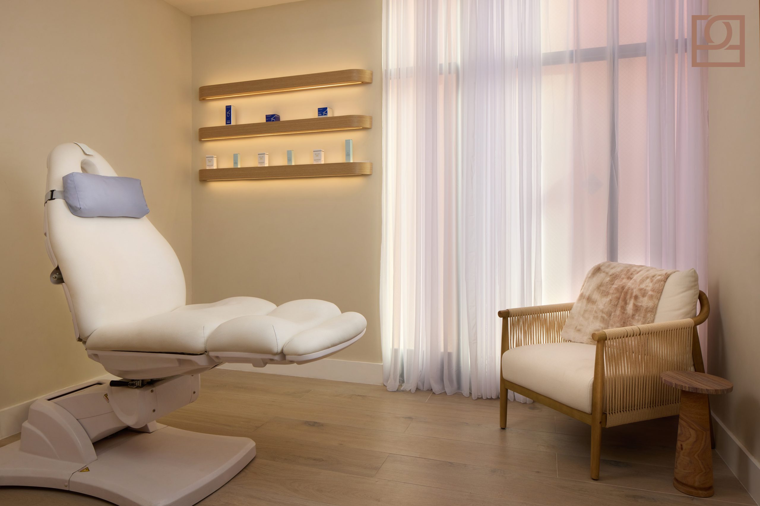 A Private, Calm Treatment Room Private treatment room at The Practice Healthcare in Beverly Hills with a white procedure chair, backlit shelving, and sheer curtains